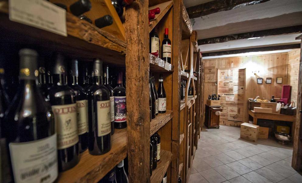 Cantina con scaffali di legno pieni di bottiglie di vino e casse di legno.