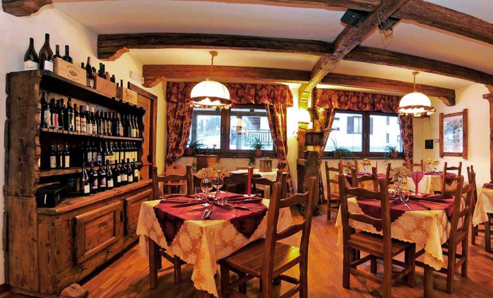 Ristorante accogliente con arredamento rustico, tavoli apparecchiati e scaffali pieni di vini.